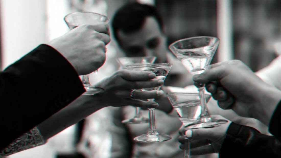 Hands raising cocktail glasses in a bar, from the addiction craving library